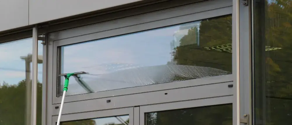 A professional window cleaner cleaning a storefront window