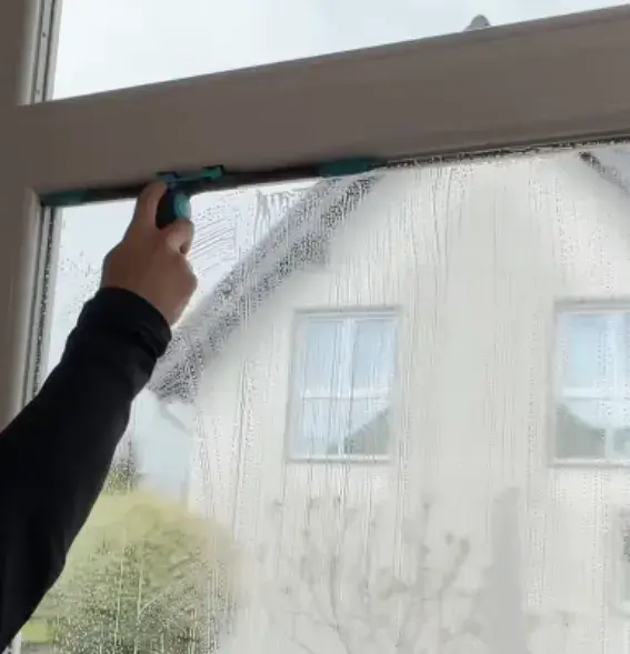A window cleaner cleaning a residential window