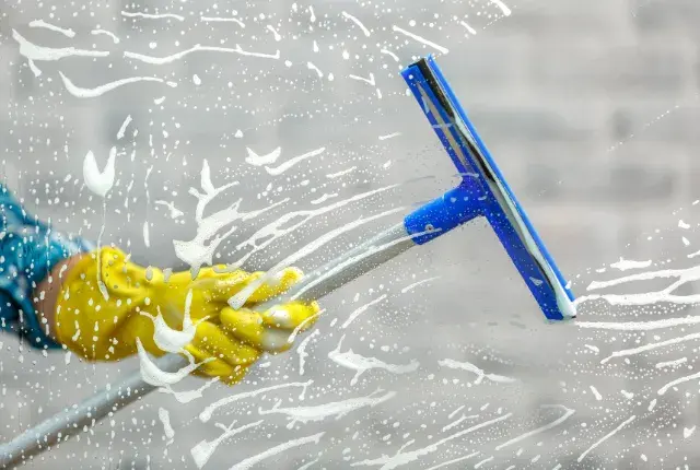 A window cleaner cleaning a window Glass