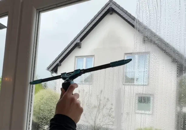 A window cleaner cleaning a window using professional tools A window cleaner cleaning a window using professional tools